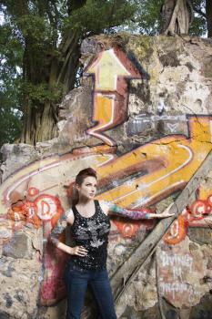 Royalty Free Photo of a Sexy Tattooed Woman Standing Next to a Wall Covered in Graffiti