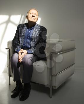 Royalty Free Photo of an Older Man Sitting in a Chair