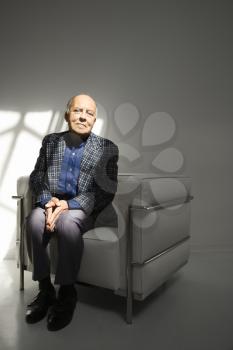 Royalty Free Photo of an Older Man Sitting in a Chair