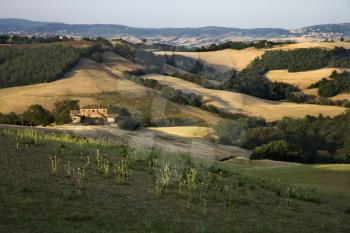 Royalty Free Photo of Rolling Hills and Building in the Countryside in Tuscany, Italy