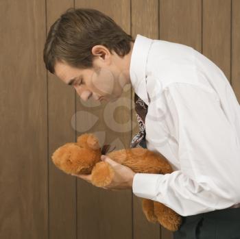 Royalty Free Photo of a Male holding a stuffed animal preparing to kiss it
