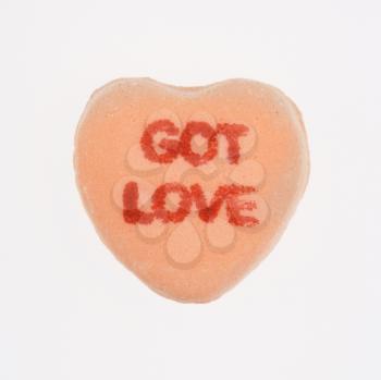Royalty Free Photo of an Orange candy heart that reads got love against white background