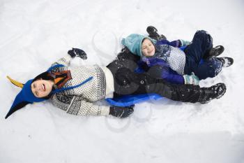 Royalty Free Photo of a Boy and Girl Lying on a Sled in the Snow