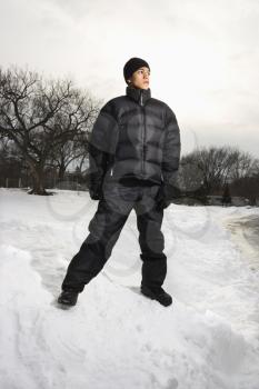 Royalty Free Photo of a Teenage Boy Standing in the Snow Wearing Winter Clothes