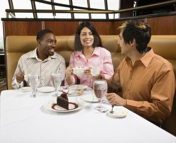 Royalty Free Photo of a Group of Friends at a Restaurant Talking and Having Dessert