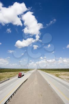 Royalty Free Photo of a Highway With a Tractor Trailer Truck and Blue Cloudy Sky