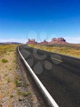 Royalty Free Photo of a Scenic Desert Road With Mountain Land Formations