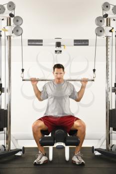 Royalty Free Photo of a Man at a Gym Lifting Weights on a Weight Machine