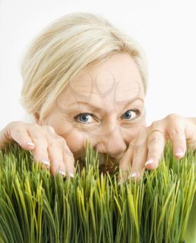 Portrait of adult Royalty Free Photo of a Blonde Woman Looking Through Grass