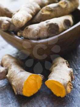 Royalty Free Photo of Pieces of Whole And Cracked Fresh Turmeric Root