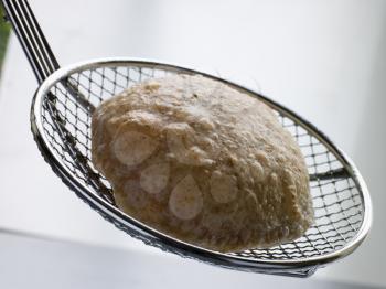 Royalty Free Photo of Deep Fried Puff Bread on a Strainer
