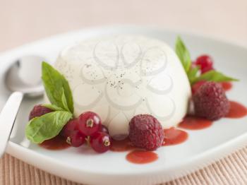 Royalty Free Photo of Vanilla Panna Cotta with Raspberries Red Currants and Coulis