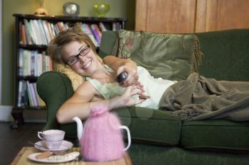 Royalty Free Photo of a Young Woman on the Sofa Watching TV