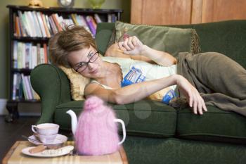 Royalty Free Photo of a Woman on a Sofa Eating Chips