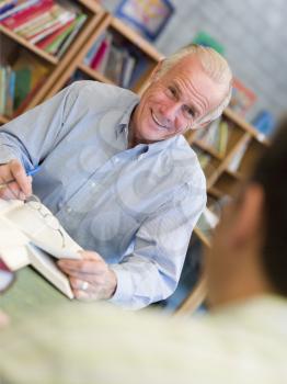 Royalty Free Photo of a Man Talking to Another Man in a Library