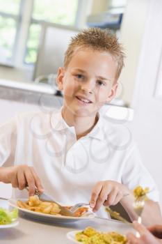 Royalty Free Photo of a Boy Eating in a Cafeteria