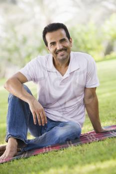 Royalty Free Photo of a Man on a Blanket at a Park