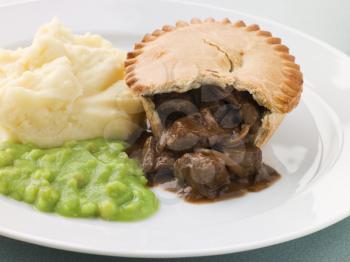 Royalty Free Photo of a Steak Pie and Mash With Mushy Peas