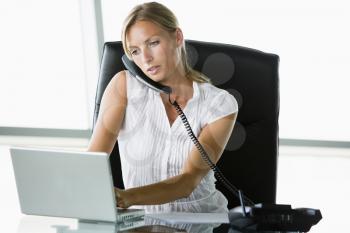 Royalty Free Photo of a Woman on the Phone Using a Laptop