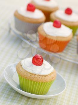 Royalty Free Photo of Iced Cupcakes with Glace Cherries