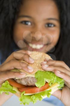 Royalty Free Photo of a Girl Eating a Cheeseburger