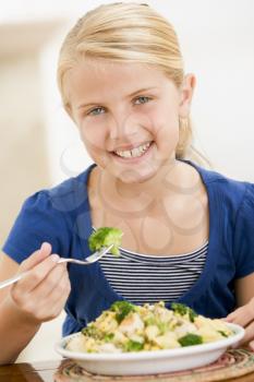 Royalty Free Photo of a Girl Eating Broccoli With Pasta