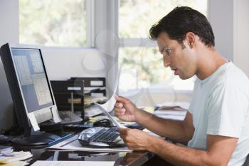 Royalty Free Photo of a Man Looking Shocked at Paperword