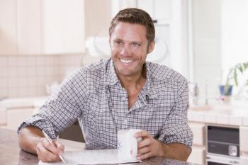 Royalty Free Photo of a Man Reading a Newspaper and Holding a Coffee