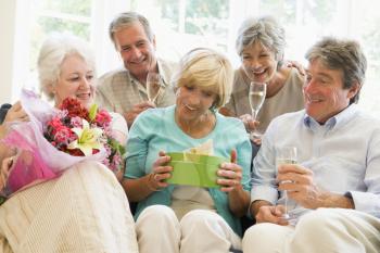 Royalty Free Photo of Five People With Champagne and Flowers and a Gift