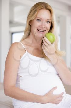 Royalty Free Photo of a Pregnant Woman Eating an Apple
