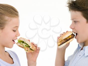 Royalty Free Photo of Kids Eating Cheeseburgers and Sandwiches