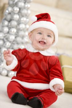 Royalty Free Photo of a Baby in a Santa Suit