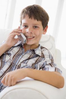 Royalty Free Photo of a Boy on a Sofa Talking on a Cellphone
