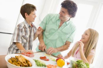 Royalty Free Photo of a Father and Children Preparing Food