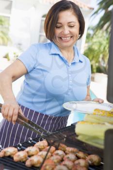 Royalty Free Photo of a Woman Barbecuing