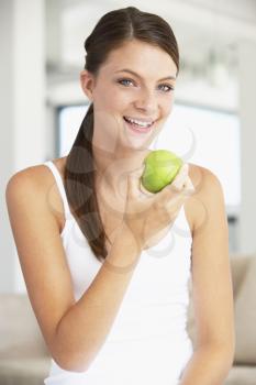 Royalty Free Photo of a Young Woman Eating a Granny Smith Apple