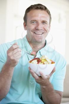 Royalty Free Photo of a Man Eating a Fruit Salad