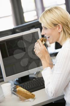 Royalty Free Photo of a Woman Having Lunch at Her Desk