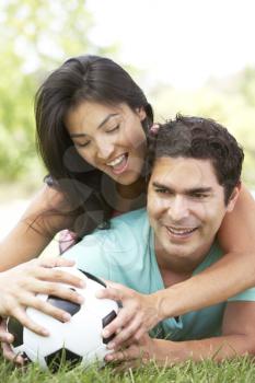 Royalty Free Photo of a Couple on the Ground With a Soccer Ball