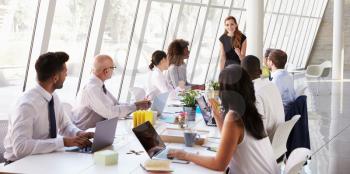 Caucasian Businesswoman Leading Meeting At Boardroom Table