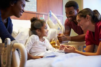 Pediatrician Visiting Parents And Child In Hospital Bed