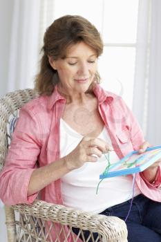 Senior woman doing cross stitch