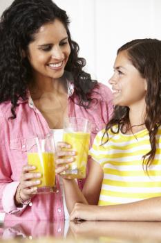 Mother and daughter drinking orange juice