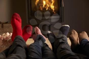 Close Up Of Familys Feet Relaxing By Cosy Log Fire With Marshmallows