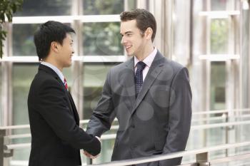 Two Businessmen Shaking Hands Outside Office