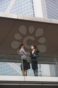 Two Businesswomen Shaking Hands Outside Office Building