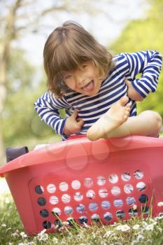 Young Boy Sitting In Laundry Basket