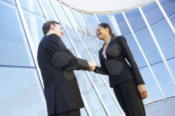 Businessman And Businesswomen Shaking Hands Outside Office