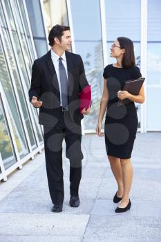 Businessman And Businesswomen Walking Outside Office