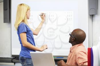 Female Student Writing Answer On Whiteboard